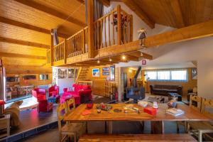 a living room with a large wooden table and red chairs at Gite&Spa le Montagnard in Saint-Jean-Saint-Nicolas