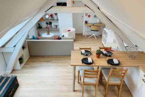 a room with a table and chairs in a attic at Sous Les Nuages in Rouen