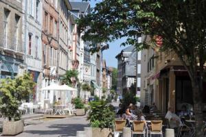 une rue de la ville avec des personnes assises à des tables et des chaises dans l'établissement Sous Les Nuages, à Rouen