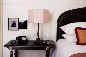 a bed with a lamp on top of it at NoMad London in London