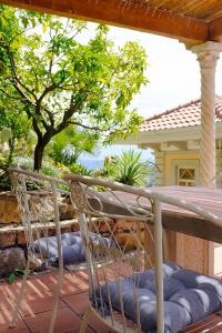 een stoel op een patio met een tafel en een boom bij Villa d'Artisti in Sanremo