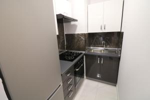 uma pequena cozinha com um fogão e um lavatório em Sneky em Pula
