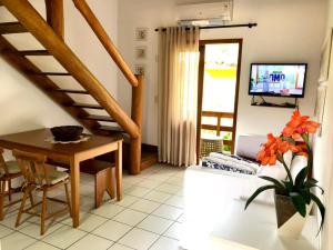 ein Wohnzimmer mit einer Treppe und einem Tisch in der Unterkunft Loft encantador em Praia do Forte próximo à Vila. in Praia do Forte