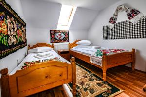 a bedroom with two beds and a rug at Pensiunea Poienita in Budeşti