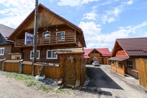 Pensiunea Poienita في Budeşti: منزل خشبي أمامه بوابة