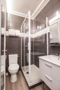 a bathroom with a toilet and a shower and a sink at Hotel De La TA in Rennes