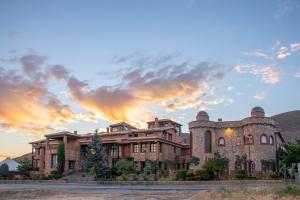 ein großes Backsteinhaus mit Sonnenuntergang im Hintergrund in der Unterkunft Hospederia del Zenete in La Calahorra