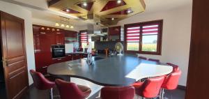 a kitchen with a large dining table and red chairs at Maison de vacances proche Strasbourg et Europa park in Sand