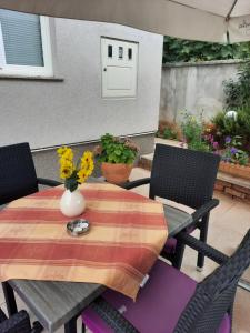 stół i krzesła z wazonem kwiatów na patio w obiekcie Apartment Sara w mieście Zadar