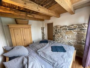 two beds in a room with a stone wall at Am Rathaus 1 in Hüfingen