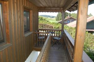 a porch of a cabin with chairs and a table at Ferienwohnung am Wirtsgarten in Bad Birnbach