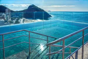 a swimming pool with a view of the ocean at Windsor Leme Hotel in Rio de Janeiro
