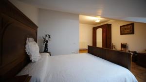 a bedroom with a large bed with white sheets at Casa Rural Plaza Vieja Saldaña in Saldaña +4 photos