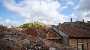 a view of roofs of buildings with a castle in the background at Casa Rural Plaza Vieja Saldaña in Saldaña