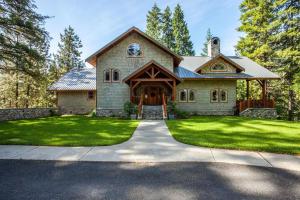 a large brick house with a driveway at Snowgrass Lodge - River, Mountain Views & Hot tub in Leavenworth