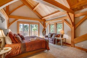 ein Schlafzimmer mit einem großen Bett und einem Sofa in der Unterkunft Snowgrass Lodge - River, Mountain Views & Hot tub in Leavenworth