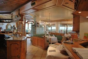 ein Restaurant mit Tischen und Stühlen in einem Zimmer in der Unterkunft Landhotel Wiesenhof in Heroldstatt