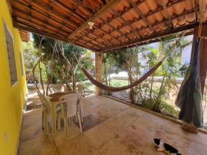 um pátio com uma mesa e cadeiras e um gato no chão em Casa do Galego no Residência Família em Canoa Quebrada