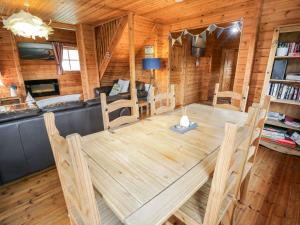a dining room with a wooden table and chairs at Sun View Lodge in Llanbedr