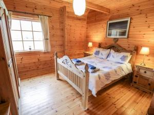 a bedroom with a bed in a log cabin at Sun View Lodge in Llanbedr