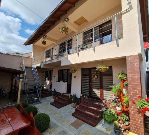 a house with stairs and a balcony with potted plants at Splendid House in Făgăraş