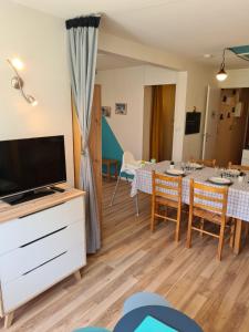 a living room with a dining table and a tv at La Mongie Yes ! in Bagnères-de-Bigorre