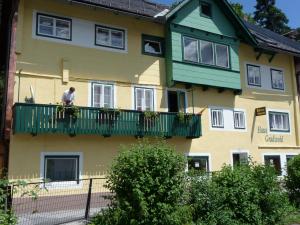 un hombre parado en un balcón de una casa en Haus Gradwohl, en Schladming