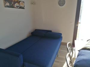1 cama con sábanas azules en una habitación en Il Piccolo Uliveto del Conero, en Camerano