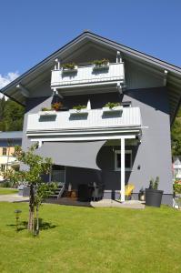 ein weißes Haus mit einem Balkon und einem Hof in der Unterkunft Ferienwohnung Nico in Mühlbach am Hochkönig