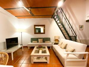 a living room with a white couch and a tv at La Buganvilla in Córdoba