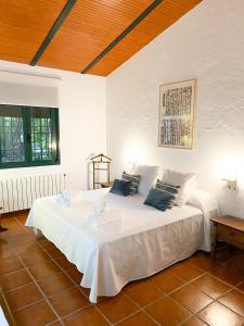 a bedroom with a bed with white sheets and blue pillows at La Buganvilla in Córdoba