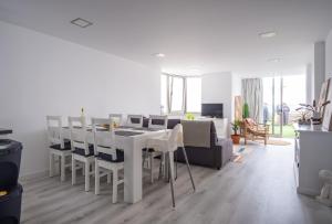 Un comedor blanco con una mesa y sillas. en Foz - West Shore Retreat, en Caldas da Rainha