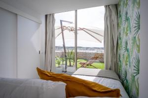Un dormitorio con una cama y una ventana grande. en Foz - West Shore Retreat, en Caldas da Rainha