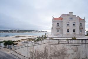 un edificio en la parte superior de una pared junto a un cuerpo de agua en Foz - West Shore Retreat, en Caldas da Rainha