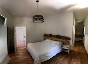 a bedroom with a large white bed and a chandelier at CASA DELLE GUARDIE b&b in Madonna di Fornelli