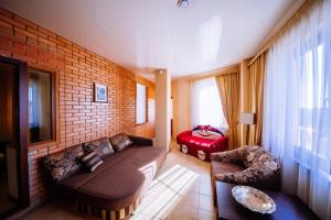a living room with a couch and a brick wall at Villa Lubomir in Vityazevo
