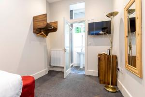 - une chambre d'hôtel avec un lit et un miroir dans l'établissement Royal Park Hotel, à Londres