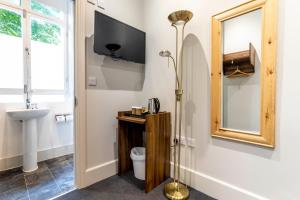Un baño con inodoro, lavabo y espejo. en Royal Park Hotel, en Londres