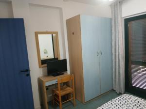 a bedroom with a desk with a television and a mirror at La Maison Du Parc in SantʼAndrea Apostolo dello Ionio