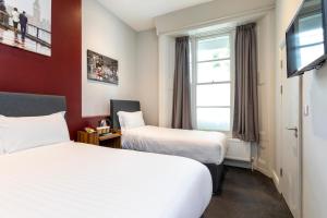 ロンドンにあるRoyal Park Hotelのベッド2台とテレビが備わるホテルルームです。