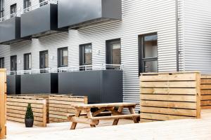 una mesa de picnic de madera frente a un edificio en The New Post Office, en Vestmannaeyjar