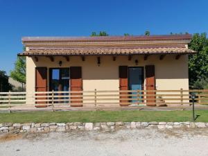 une petite maison avec une clôture devant elle dans l'établissement Il Piccolo Uliveto del Conero, à Camerano