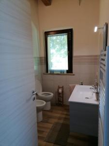 baño con aseo y lavabo y ventana en Il Piccolo Uliveto del Conero, en Camerano