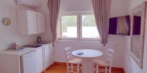 a kitchen with a table and chairs and a window at Henry Agriturismo Manfredonia in Ippocampo