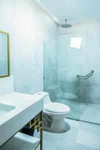 a bathroom with a toilet and a glass shower at Casa Bolívar Hotel Museo in Loja