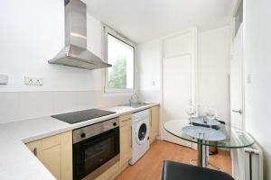 a kitchen with a sink and a washing machine at Nice Apartment - Great Portland St, Regents Pk, Euston in London