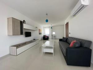un soggiorno con divano e tavolo di Sunshine Apartments Mellieha - modern three bedroom apartment - Apt No 2 a Mellieħa