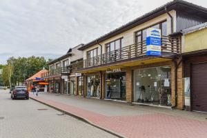 a street with shops and a car driving down a street at Palanga Center Studios in Palanga