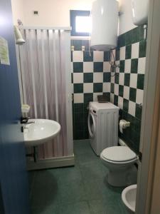 a bathroom with a toilet and a sink at La Maison Du Parc in SantʼAndrea Apostolo dello Ionio +15 photos