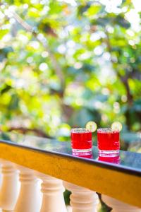 two red solo cups on a table with a railing at Primavera Holiday Homes-GOA-CANDOLIM BEACH WITHIN 300 MTRS-GOAN FAMILY HOSPITALITY in Candolim